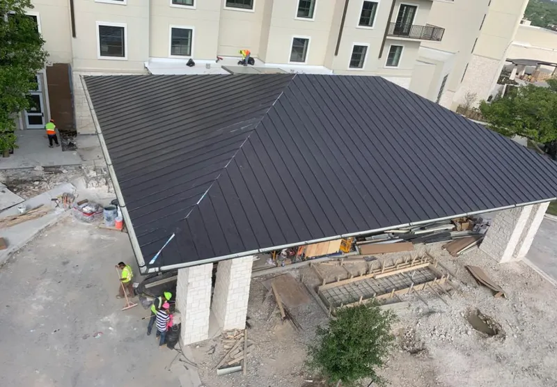 Metal roofing installation team working on a commercial building in Brushy Creek